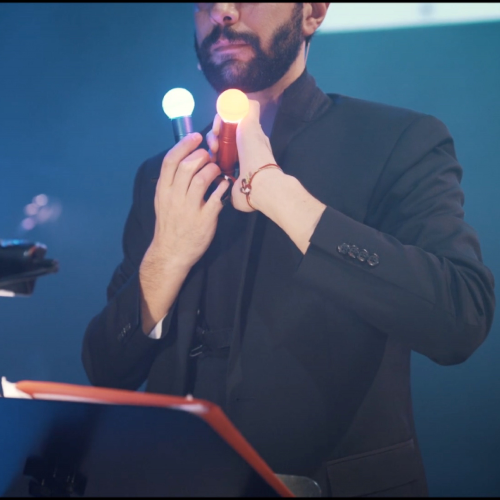 A musician holding two glowing controllers during LULELA